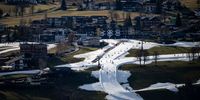 SCHLADMING, AUSTRIA - JANUARY 06: Skiers descend the slopes of the Rohrmoos skiing area covered in artificial snow as grass covers the rest of the hill on either side on January 6, 2023 in Schladming, Austria. Alpine ski resorts in Austria, Germany and Switzerland are facing an unseasonably warm January that has brought record temperatures to many parts of Europe.  (Photo by Daniel Kopatsch/Getty Images)