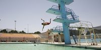 epaselect epa09955811 A man jumps into a pool during a heatwave in Sana'a, Yemen, 18 May 2022. The Yemen meteorological service has warned of a heatwave and dry weather in most parts of the Arab country with daytime maximum temperatures ranging between 37-41 degrees Celsius.  EPA-EFE/YAHYA ARHAB
