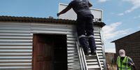 LighTec technicians Brian Mataya and McDonald Mutuva install a solar panel on the roof of a shack in the informal settlement of Melusi. (Photo: Felix Dlangamandla