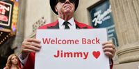 Gregg Donovan displays a "Welcome Back Jimmy" sign outside the El Capitan Entertainment Centre in Hollywood where the "Jimmy Kimmel Live!" show will be recorded on the first night of the show's return to the ABC lineup on September 23, 2025 in Los Angeles, California. Kimmel's ABC late-night show is returning tonight after being suspended following controversy over his comments about the suspected shooter of Charlie Kirk. (Photo by Mario Tama/Getty Images)