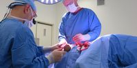 Dr Kairinos , left, removes a piece of bone which creates pressure on the skin when the patient lies on their side. It increases the chance of developing a bedsore. He is assisted by Dr Landau. (Photo: Elsabé Brits)