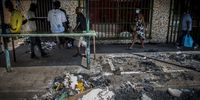 People walk past the burnt remains of a stall belonging to Uber Syll from Senegal,  8 March 2021. Syll said the government was supposed to help foreigners, but had failed to do so. (Photo: Shiraaz Mohamed)
