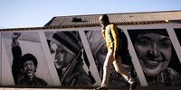 A man walks by a murial of the late Winnie Mandela.<br>(Photo: Shiraaz Mohamed)