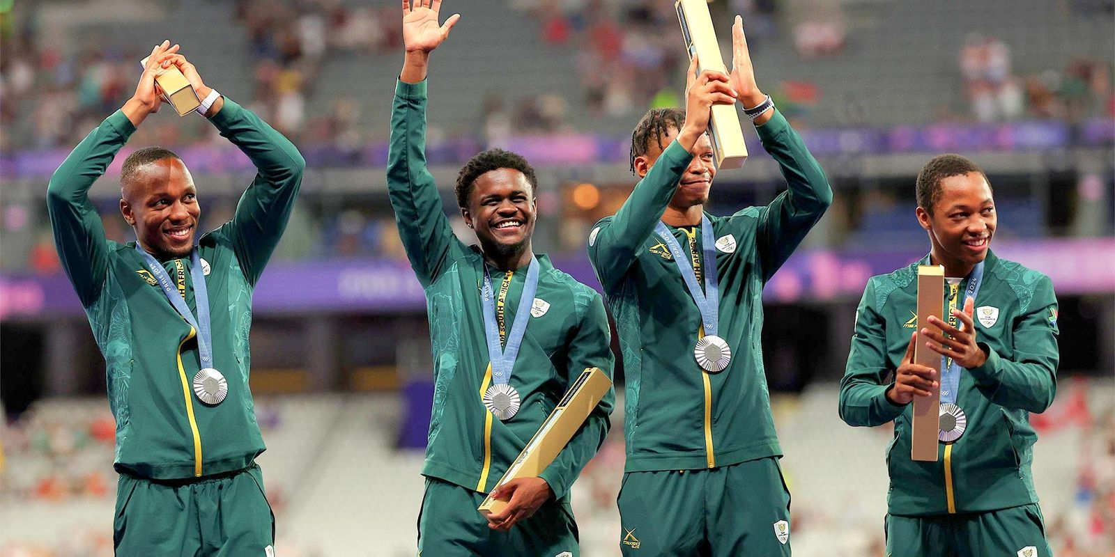 Team South Africa celebrate on the podium at the men’s  4x100m medal ceremony