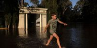 FORBES, AUSTRALIA - NOVEMBER 16: Benedict plays in ankle deep water as the Lachlan River starts to spill over on November 16, 2021 in Forbes, Australia. Residents in Forbes and around Central West NSW are preparing to evacuate as floodwaters inundate the region following heavy rains across the state. The Bureau of Meteorology is predicting possible major flooding at Forbes from Tuesday. (Photo by Brook Mitchell/Getty Images)