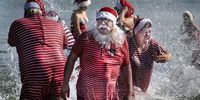 epaselect epa07735223 Participants in the World Santa Claus Congress have their annual saltwater foot bath at Bellevue Beach, at Bakken, north of Copenhagen, Denmark, 23 July 2019. The annual eventruns from 22 to 26 July.  EPA-EFE/Liselotte Sabroe  DENMARK OUT