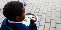 A scholar at Cosmo City Junior Primary school eating his daily NSNP meal. Many scholars didn’t get access to their NSNP meal when schools were closed for fogging. (Photo:Julia Evans)