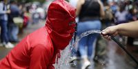 A faithful (L) acting as one of the Talciguines (possesed people) takes a refreshment while taking part during the celebration of the Holy Monday on occasion of Salvadoran Holy Week in Texistepeque, El Salvador, 03 April 2023.  EPA-EFE/RODRIGO SURA