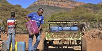 Oliver Marokoana loads his donkey cart with water containers for his sons to take home while he waits in the queue at the water source in Setoking village.( Photo: Lucas Ledwaba/Mukurukuru Media)