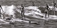 Tony Heard, far right, up and riding on the same wave with some of South Africa’s first surfers in the early 1950s at South Beach in Durban. (Photo: Supplied)<br>