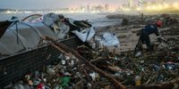 The wreckage of a road tanker lies among the rubbish washed up on a Durban beach. Eighteen rivers pass through the city on their way to the sea. The damage wrought by the flood on the popular tourist destination could be more than R25bn, a city official estimated. (Photo: Gallo Images / Darren Stewart)