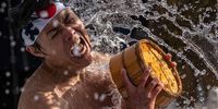 TOKYO, JAPAN - JANUARY 15: A man pours ice-cold water over himself during a purification ritual at Kanda Myojin shrine on January 15, 2022 in Tokyo, Japan. The coming of age purification ritual is held annually each January at Kanda Myojin Shrine to honour and pay homage to Daikoku, the deity of fortune, and involves people pouring ice-cold water over themselves in a pool of water and ice blocks to purify themselves to traditional Japanese music. The ceremony was scaled back significantly this year in an attempt to reduce the spread of COVID-19. (Photo by Carl Court/Getty Images)