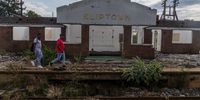 Two men walk past the deserted Kliptown Train Station in Johannesburg on Wednesday. (Photo: Shiraaz Mohamed)