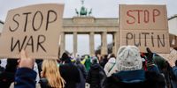 BERLIN, GERMANY - FEBRUARY 24: People protesting against Russian invasion of Ukraine hold banners reading "Stop War and Stop Putin" in front of Brandenburg gate on February 24, 2022 in Berlin, Germany. Russia began a large-scale attack on Ukraine, with explosions reported in multiple cities and far outside the restive eastern regions held by Russian-backed rebels. (Photo by Hannibal Hanschke/Getty Images)