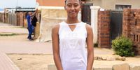 Andile Sibeko stands in front of her home in Soweto. (Photo: Sumeya Gasa)