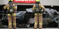 epa09421430 Fire fighters stand near a burnt out car in Melbourne, Australia, 20 August 2021. According to the police, at least two people inside the car died in the explosion.  EPA-EFE/LUIS ASCUI  AUSTRALIA AND NEW ZEALAND OUT ATTENTION EDITORS: PART OF IMAGE HAS BEEN BLURRED