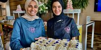 Sisters and business partners Zainab, left, and Faatimah Paruk set up the dessert table at a corporate event. (Photo: Wanda Hennig)<br>