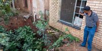 Ramoitoi Molebo observes the sinkhole directly below the bedroom window of his mother's home in Khutsong. The sinkhole appeared in 2019 and continues to expand and destabilise the house during heavy rain. (Photo: Chris Collingridge)